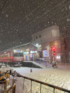 a train traveling down tracks next to snow covered ground