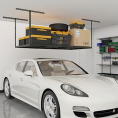 a white car is parked in a garage with tools on the rack above it and shelves below