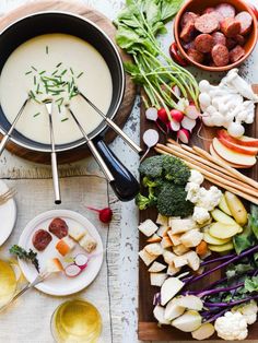 an assortment of food is displayed on a table with bowls and utensils next to it