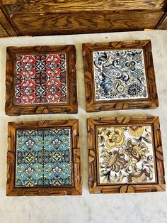 four square wooden frames with colorful designs on the inside and outside, hanging on a wall