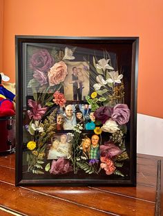 a wooden table topped with a frame filled with pictures and flowers next to a teddy bear