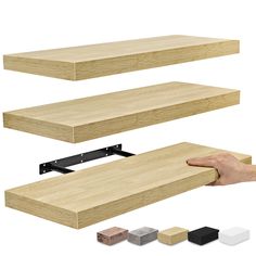 a hand is holding the edge of a wooden shelf with different colors and sizes on it