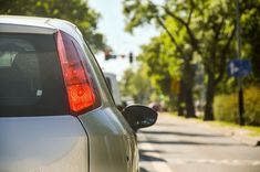 a car is parked on the side of the road with its tail lights turned red