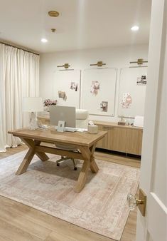 a laptop on a wooden table in a room with white walls and wood flooring