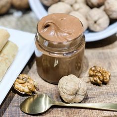 some food is sitting on a table next to spoons and plates with peanut butter