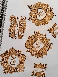 hendi tattoos on a spiral notebook with the letter s in gold and paisley designs