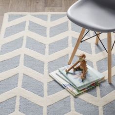 a chair sitting on top of a blue rug next to a table with a stuffed animal