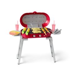 a red and white barbecue grill with drinks on the side, next to it's tray