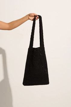 Lovingly handcrafted from 100% cotton using our signature in-house technique, the Piccolo Crochet Bag in Black features a relaxed tote shape, a fixed wide strap and an intricately woven square pattern. Designed to fit all of your sunshine essentials and carry you through summer moments with ease. The Piccolo was handmade in Bali, taking 2 days to carefully complete each piece. Black Rectangular Cotton Hobo Bag, Black Cotton Rectangular Hobo Bag, Eco-friendly Black Crochet Bag With Braided Handles, Black Cotton Tote Hobo Bag, Black Cotton Hobo Tote Bag, Black Square Cotton Bag, Eco-friendly Black Woven Shoulder Bag, Chic Black Cotton Shoulder Bag, Eco-friendly Black Crochet Tote Bag