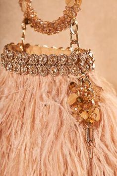 Beige, gold handcrafted ostrich feather bag, featuring jeweled elements on its bag opening and a jeweled bracelet handle. - Aza Fashions Luxury Formal Bags With Feathers, Luxury Formal Feathered Bags, Luxury Evening Bags With Feather Trim, Luxury Evening Bag With Feather Trim, Luxury Hand-embellished Gold Bags, Luxury Hand Embellished Gold Bags, Luxury Gold Hand Embellished Bags, Luxury Handmade Bags For Reception, Luxury Hand Embellished Bag For Events