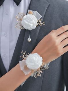 a close up of a person wearing a suit and tie with two flowers on it