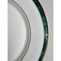 a white plate with green and gold trim