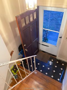 an overhead view of a door and stairs leading up to a room with a window