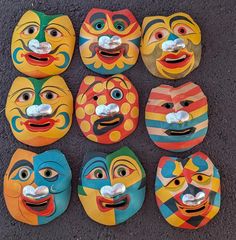 several colorful masks are arranged in rows on the ground