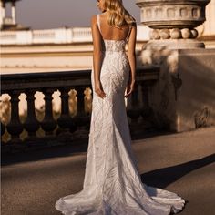 a woman in a wedding dress standing on a bridge