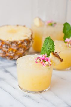 pineapple cocktails with mint garnish on the rim and in small glasses