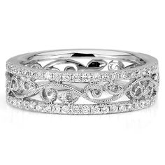 a wedding band with two rows of diamonds in the center and an intricate design on the side