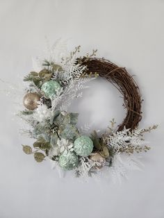 a wreath with white and green ornaments on it