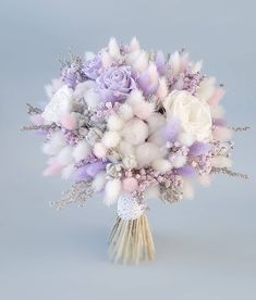 a bouquet of white and purple flowers on a gray background with fluffy pink feathers in the center