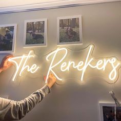 a person holding up a neon sign that says the reekiers