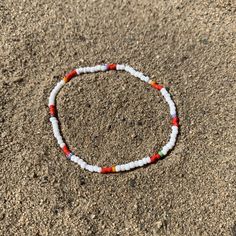 white seed beads with a pattern of shiny red, striped and solids strung on elastic please gently roll off and on to prolong its life handmade in venice, ca White Bohemian Stretch Bracelet For Festivals, Beach Red Friendship Bracelets With Colorful Beads, Red Beaded Stretch Bracelet For Festival, Beach-friendly Red Colorful Beads Friendship Bracelets, Casual White Beaded Bracelets For Festivals, Casual White Stretch Bracelet For Festivals, Red Beaded Bracelets With Letter Beads For Beach, White Beaded Bracelets With Spacer Beads For Beach, White Beach Friendship Bracelets With Spacer Beads