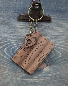 a wooden keychain with a heart shaped tag attached to it