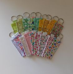 a bunch of different colored cloths hanging from a metal hook on a white wall