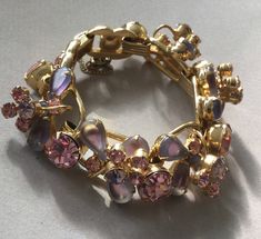 "Delizza and Elster, Juliana design with pink rhinestones and givre lavender satin glass teardrop accents. Beautiful, sparkling diamond like gems on this lovely link bracelet with a gold finish. A larger pink chaton is on a link that links two other ornate gem clusters. A total of five clusters and six large gem connectors. There is a chain guard as well as the very secure clasp. Wear this lovely bracelet on your fanciest outing. Quite a stunning and rare Juliana by Deliza and Elster from their Elegant Pink Metal Crystal Bracelet, Pink Crystal Bracelet For Formal Occasions, Pink Crystal Bracelets For Formal Occasions, Formal Pink Crystal Bracelet, Pink Sparkling Stones Bracelet For Wedding, Pink Wedding Bracelets With Sparkling Stones, Pink Teardrop Jewelry For Evening, Pink Rhinestone Costume Jewelry, Adjustable Jeweled Jewelry For Evening