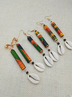 The handmade cowrie African Kente earrings are approximately 3.75 inches long. The earrings will come with back stoppers. They are available in pierced and non pierced options. The earrings come with back stoppers. These can vary in length due to sizes of natural shells. If you have any questions please feel free to contact us at anytime.                  Tips and Suggestions for Clip On (Non Pierced) Earrings to fit your ears comfortably: Clip on feels loose: Go slow and adjust carefully 1.Use your fingers or a small pair of pliers to gently open the fold, bringing the pad closer to the back of the earring. 2.Use pliers and slowly, gently tighten up the U shape at bottom 3.Try clip on pads Clip on feels tight: Test frequently as your adjusting them 1. Use your pliers to bring the pad slig Afro Earrings, Cowrie Shell Earrings, African Inspired Jewelry, Afrocentric Earrings, Non Pierced Earrings, African Accessories, African Earrings, African Jewelry, Cowrie Shell