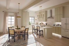 a kitchen and dining room are shown in this image, with light wood flooring