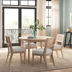 a dining room table with chairs and a potted plant