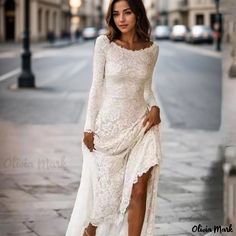 a woman in a white dress posing on the street