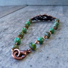 "This bracelet is the perfect match to several of the dark green items in my shop (with more to come). I love this lightweight copper bracelet with the scroll design accent. The beads on this bracelet are 3x5mm, and 4mm melon beads. The beads are small and delicate. I put a slight curve in the copper connector. It makes it lay comfortably on the wrist. This bracelet is offered in a variety of sizes, so the number of beads may be slightly different than what is pictured. If you are ordering for a Beaded Bronze Copper Bracelets, Bronze Beaded Copper Bracelets, Green Bohemian Bracelets With Patina, Green Patina Bracelet As A Gift, Green Patina Bracelet As Gift, Green Bracelet With Patina As Gift, Green Bracelets With Patina As Gift, Dark Green Bracelet, Short Beaded Necklace