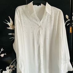 This White Collared Blouse Is Adorned With Iridescent Shift Mainly Blue Rhinestones. It Is Made Of 97% Polyester 3% Spandex. Pit To Pit 22 Inches, Length 32 Inches. Elegant Long Sleeve Sequin Shirt, Elegant Long Sleeve Shirt With Rhinestones, Elegant Embellished Summer Shirt, Elegant Party Shirt With Rhinestones, Elegant Embellished Spring Shirt, White Embellished Top For Work, Elegant Bedazzled Tops For Evening, White Long Sleeve Tops With Rhinestones, Rhinestone Blouse For Spring