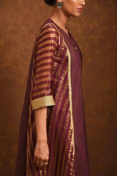 Wine dress with handwoven tissue stripes, zardosi work and front button placket.
Component: 1
Embroidered
Neckline: Round
Sleeve Length: Three quarter
Fabric: Handwoven Tissue Stripes, Woven Chanderi
Color: Maroon

Front button placket - Aza Fashions Handloom Cotton Silk Dress For Diwali, Cotton Silk Straight Kurta With Gota Work, Festive Handloom Chanderi Dress, Designer Chanderi Handloom Dresses, Designer Tussar Silk Straight Kurta Dress, Festive Handloom Straight Kurta Dress, Designer Chanderi Handloom Kurta, Designer Handloom Salwar Kameez With Straight Kurta, Handloom Chanderi Straight Kurta