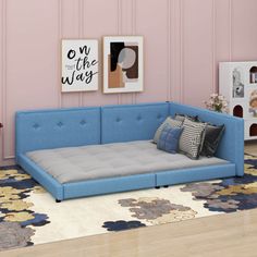 a living room with pink walls and blue couch