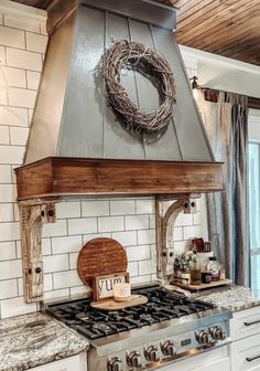 a stove top oven sitting inside of a kitchen next to a counter with a wreath on it