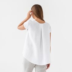 "Loose fit linen blouse TAHOE in white color is here to become your most loved piece for warm-weather outfits. Oversized, short sleeves, asymmetric hemline - our linen top has everything you need to feel chill & stylish. Perfectly suitable for summer escapes but equally works for an office look. Please note that actual colors may vary due to the many variations in monitors and browsers. DETAILS * Oversized silhouette * Short sleeves * Asymmetric hemline * True to size * Model is wearing size S a Everyday White Linen T-shirt, Relaxed White Blouse For Everyday, Relaxed White Linen Top, White Short Sleeve Blouse For Everyday, Casual White Linen Blouse, White Linen Crew Neck Blouse, Simple White Linen Top, White Linen T-shirt For Everyday, Everyday White Linen Top