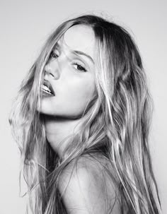 a black and white photo of a woman with her hair blowing in the wind,