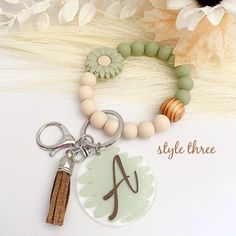 a keychain with a wooden bead and a name tag attached to it