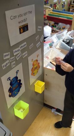 a person standing in front of a refrigerator with magnets on the back of it