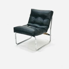 a black leather chair sitting on top of a white floor next to a metal frame