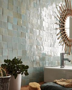 a bathroom with a sink, mirror and potted plants