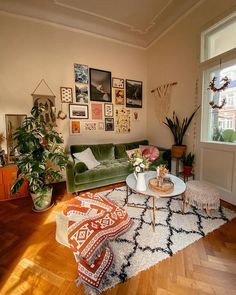 a living room with green couches and pictures on the wall above them, along with white rugs