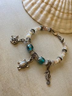 Cute charm bracelet with beachy feel; Natural stones and blue glass beads; Silver tone spacer beads and clasp; Smoke-free, pet-free studio; Comes in a gift box, ready for gifting Turquoise Drop Earrings, Natural Stone Beads, I N, Cute Charms, Beaded Dangle Earrings, Genuine Turquoise, Beaded Dangles, Spacer Beads, Blue Glass