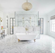 an elegant bathroom with marble floors and white fixtures, including a claw foot bathtub