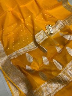 Exclusive Pure Chiffon Georgette Banarasi silk Saree With floral zari work pattern.PRODUCT DETAILSAuction For: 1 Saree with Blouse PieceColor: As shown in the pictureCondition: NewWork: FloralSaree length : 5.5 metersBlouse length : 0.8 metersWashing Instructions: Dry Clean OnlyOccasions: Wedding Wear, Party Wear, Festive Wear, Durga Puja, Indian Wear, Sangeet Wear, Bridal Wear, Chrismas Day, Mothers Day, Haldi Wear.Fall and Pico: On request (Please contact for fall and piku work)Blouse stitchin Affordable Banarasi Silk Dupatta, Luxury Banarasi Silk Fabric For Diwali, Gold Georgette Traditional Wear For Diwali, Traditional Blouse Piece With Sheer Dupatta For Celebration, Transitional Georgette Blouse Piece With Zari Weaving, Silk Traditional Wear With Cutdana For Celebration, Unstitched Gold Georgette Blouse Piece, Eid Traditional Zari Weaving On Georgette Wear, Gold Georgette Traditional Wear For Festivals