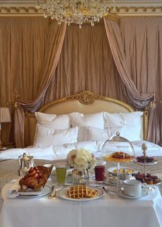 a bed room with a neatly made bed and trays of food