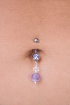 "Strengthen your intuition with this amethyst dangle belly ring. Made with ethereal shades of lilac, deep purples, holographic clears and hints of creme. The vibe of this piece is reminiscent of a magical woodland <3 Amethyst also happens to be the birthstone of February! Made with 7/16\" inch (11 mm) length bar; ball sizes are 5mm and 8mm. Bar is 14 gauge. To prolong lifetime of piece, remove before showering/bathing/swimming and keep in a cool, dry environment! Handmade in Davis, CA! First Pho Purple Belly Ring, Purple Belly Piercing, Purple Internally Threaded Jewelry As A Gift, Purple Internally Threaded Jewelry Gift, Adjustable Dangle Belly Rings, Adjustable Sterling Silver Dangle Belly Rings, Mystical Internally Threaded Jewelry For Gifts, Mystical Internally Threaded Jewelry For Gift, Mystical Internally Threaded Jewelry As Gift