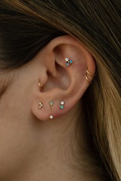 a close up of a person's ear with three piercings